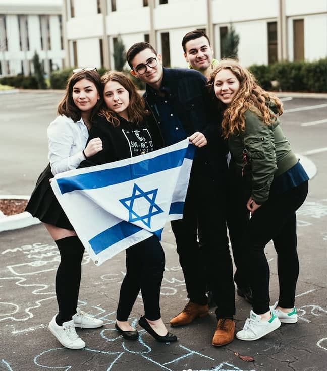 Club Z teens standing together with an Israeli flag